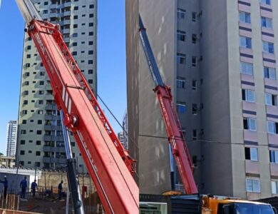 Guindaste realizando montagem de estrutura metálica