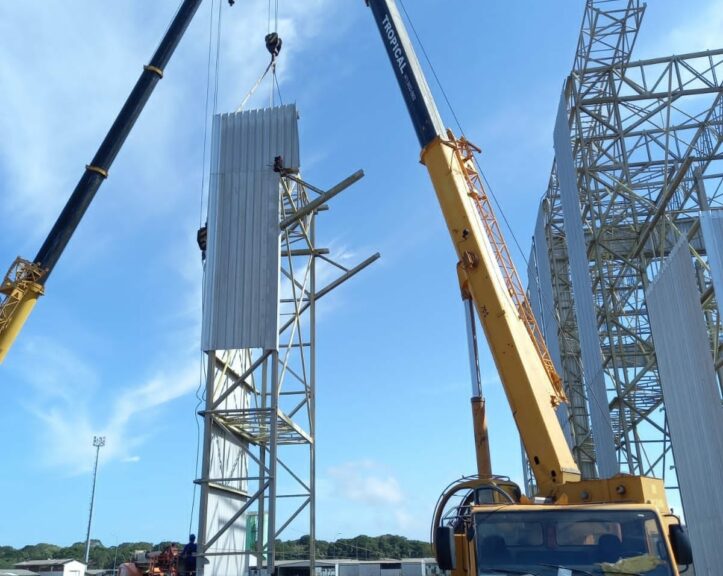 Guindaste realizando montagem de estrutura metálica