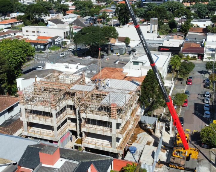 Guindaste realizando montagem de estrutura metálica