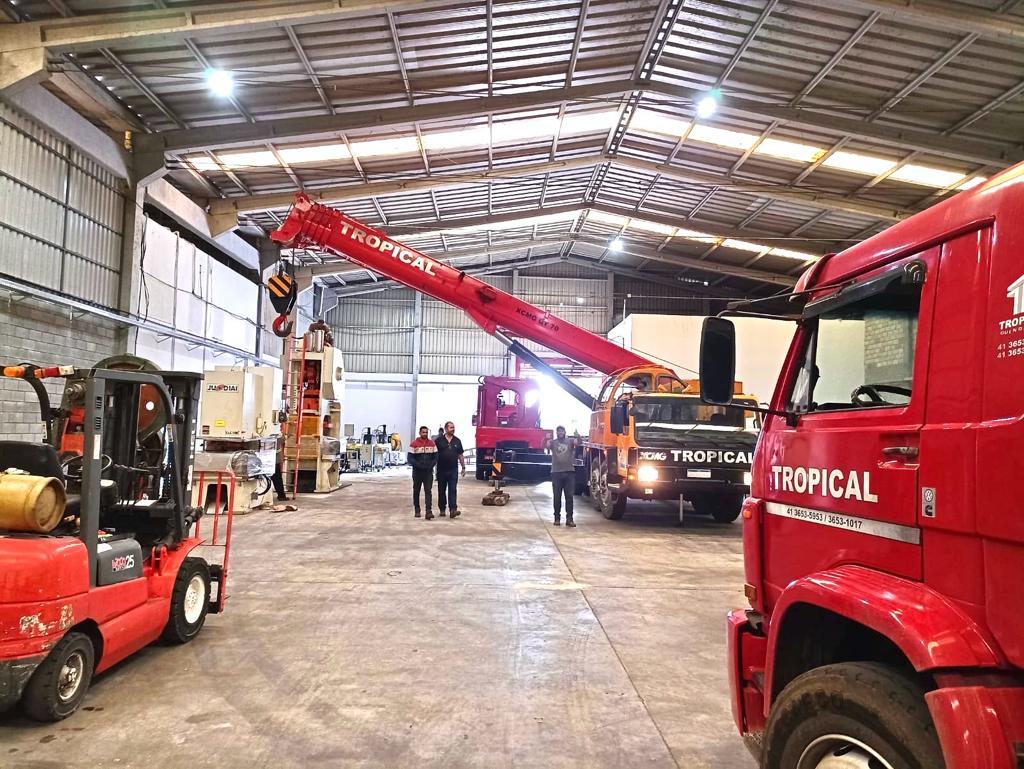 Guindaste realizando içamento de carga pesada em obra industrial